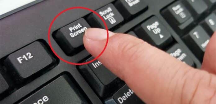 a man pressing button on keyboard to show How to Take a Screenshot on Windows