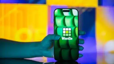 Image showing a man holding a phone to play wordle