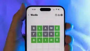 Image showing a mobile phone in a hand of a man playing Wordle
