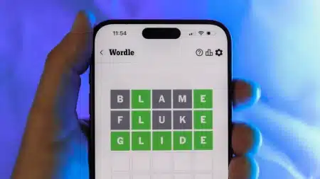 Image showing a mobile phone in a hand of a man playing Wordle